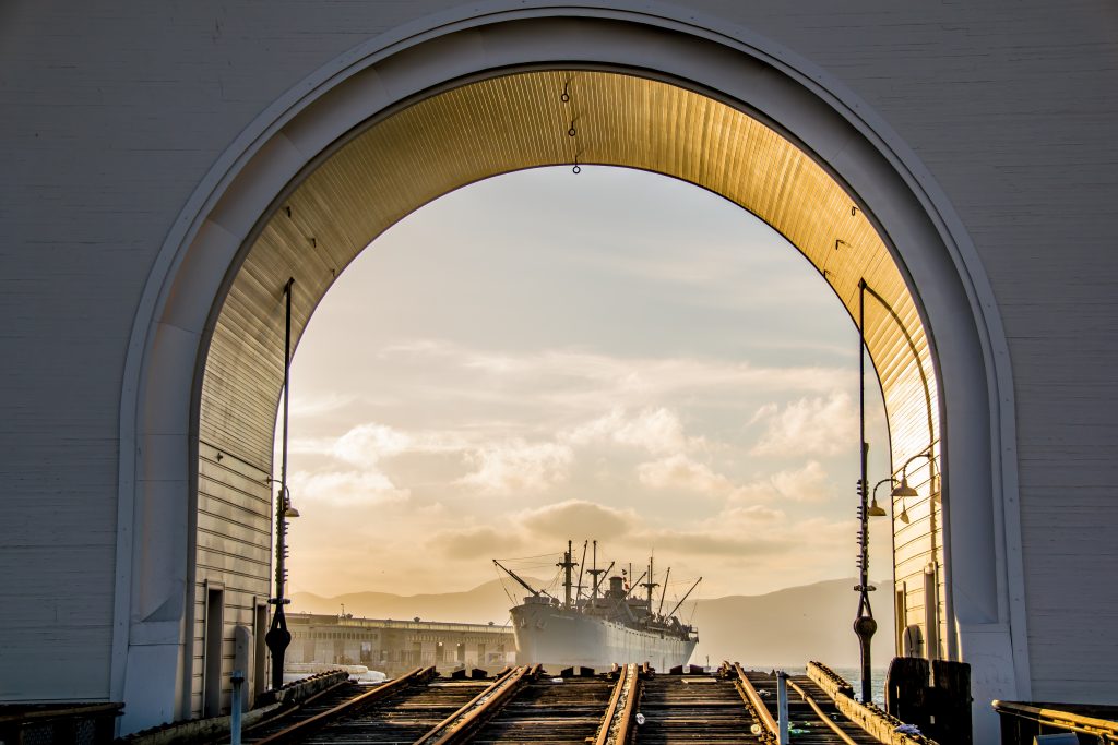 photo of ship on san francisco bay through arch structure 