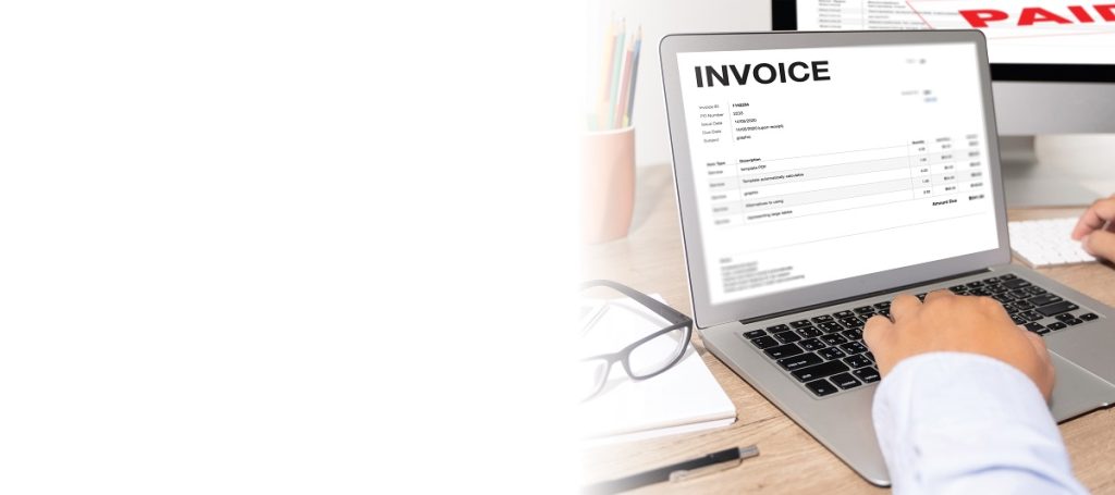 Business man using invoicing software on a laptop 